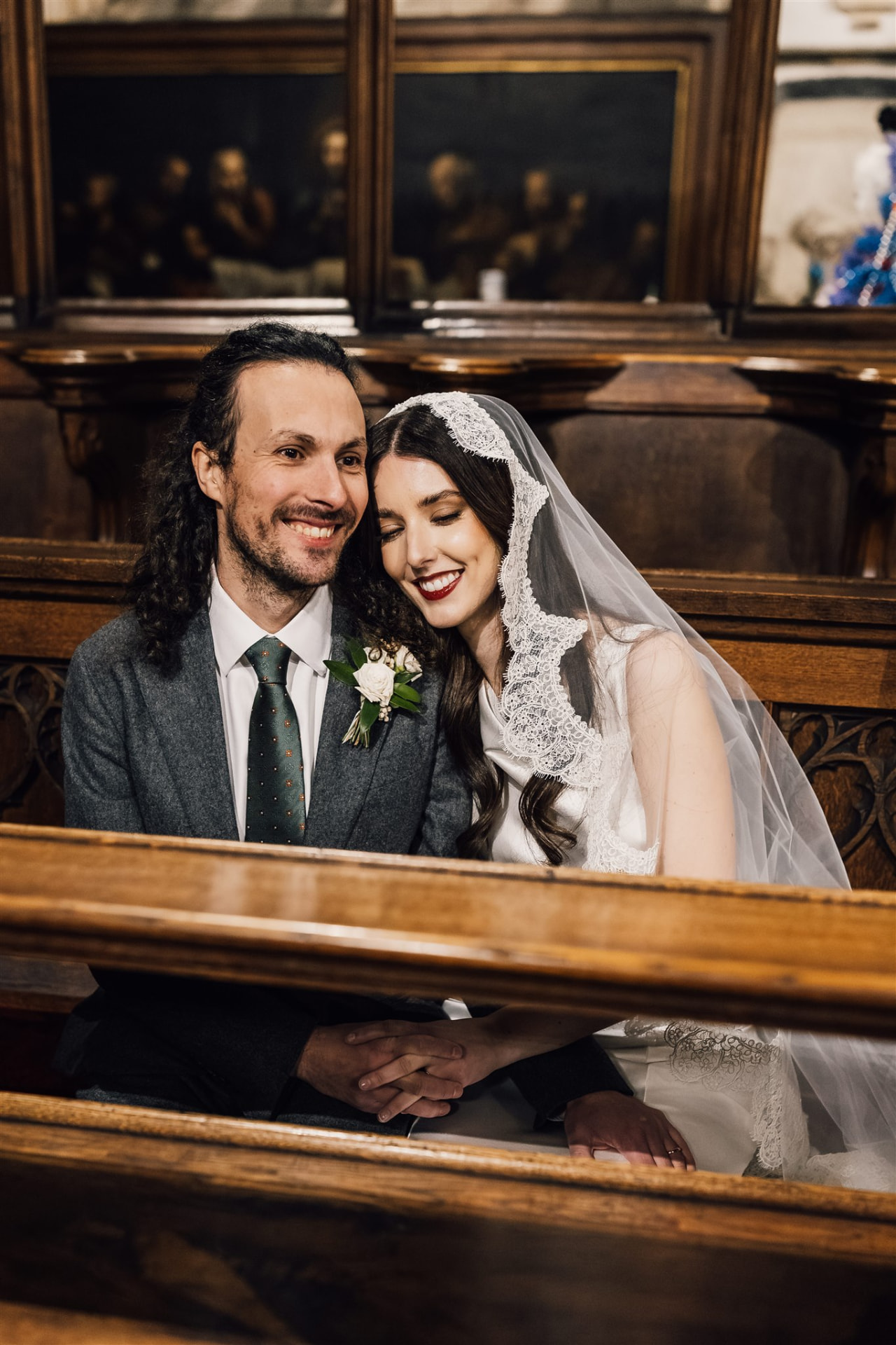 Bride and groom sitting together in a church pew.