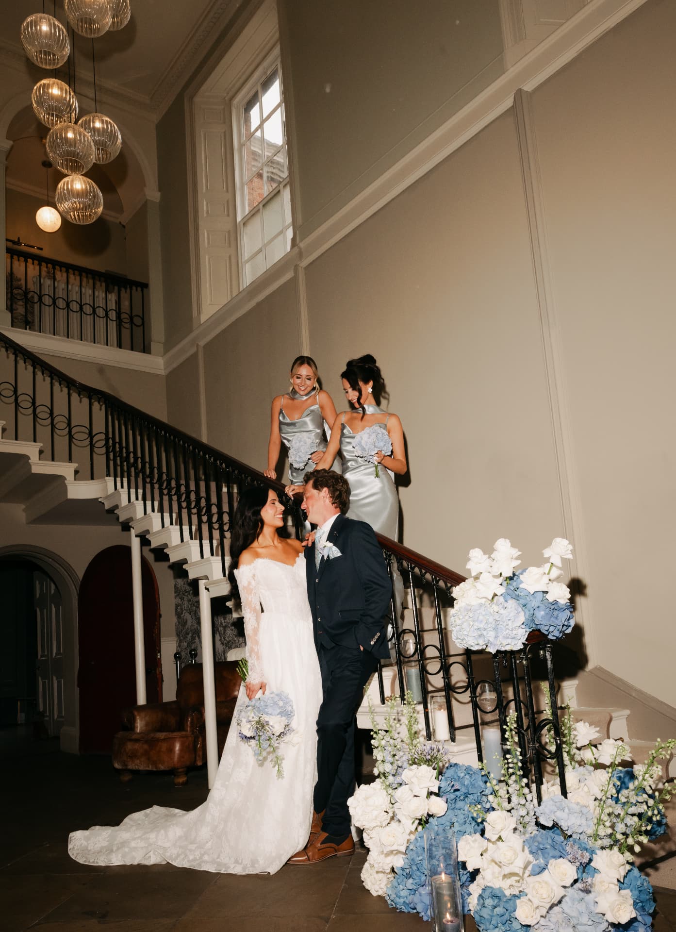 Bride and groom on a staircase dressed with blue and white hydrangeas.